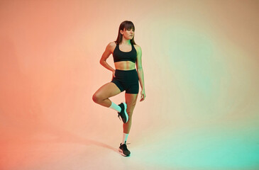 Fototapeta na wymiar Young woman in fitness clothes is in the studio