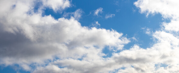 White curly clouds in the blue sky in sunny weather