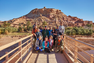 Tourists capture a shared moment, smiling and posing for a group photo against the historic...