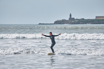 A young female surfer gracefully rides the waves on her board along the shores of Essaouira, Morocco