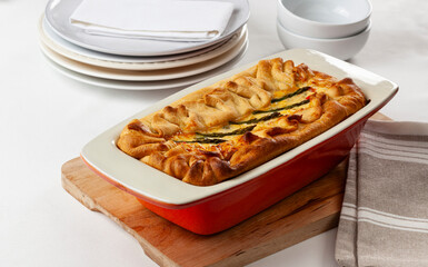 Vegetable pie with baked shortcrust pastry, in a red and white ceramic mold,