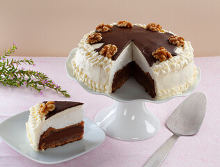 Traditional Serbian cake, Vasina cake, with nuts and chocolate on a pink tablecloth.