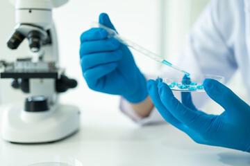 Laboratory concept: Close-up of chemicals in a laboratory, a biochemist is conducting experiments in a controlled environment in a laboratory. Doctor wearing gloves holding a test tube