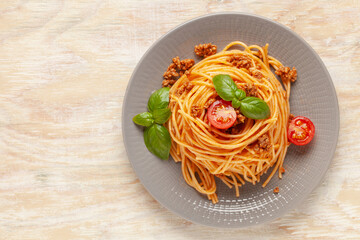 Pasta Spaghetti Bolognese in gray plate on wooden background. Bolognese sauce is classic italian cuisine dish. Popular italian food. Top view