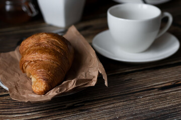 Morning with a cup of coffee and croissants. on a dark wooden background. Breakfast.