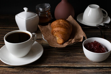 Morning with a cup of coffee and croissants. on a dark wooden background. Breakfast.