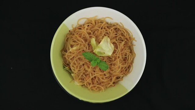 Bihun goreng, fried bee hoon, mee hoon, or rice vermicelli with vegetables and chili. A food with delicious, spicy and sweet taste on rotating display