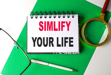 SIMPLIFY YOUR LIFE text on notebook on green paper