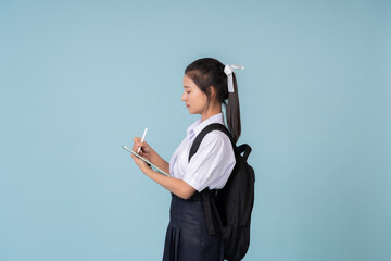 Asian female high school student Taking photos in a studio with a blue background Carry a bag and...