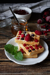 Hungarian waffles with berries on a wooden background. Breakfast. Dessert