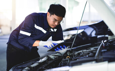 The mechanic opens the hood of the car to inspect the engine for damage and perform professional...