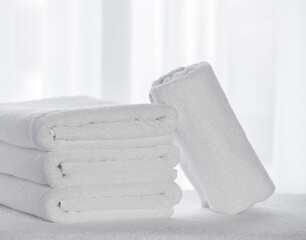 Bathroom textiles. White terry towels folded on a light background