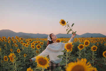 woman holding sunflower in the sunflower field, nature