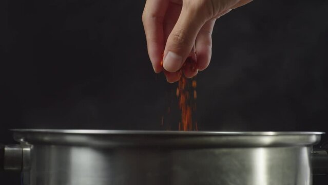 Chef's Hand Adding Paprika, Red Chili Powder In The Soup Pot. Sukiyaki Or Shabu
