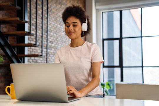 Lovely afrcian woman working on laptop while sitting at home