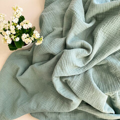 Soft fluffy thym green muslin blanket. Organic double gauze cotton fabric.  - obrazy, fototapety, plakaty