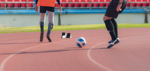 Soccer player kicking the ball on the track in the stadium with disabled athletes training sessions.
