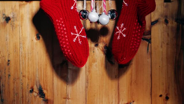 Christmas wool stockings and baubles on rustic wooden background 