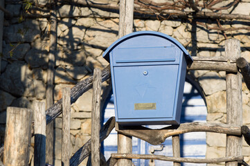 Blue mailbox outside the entrance of a house in the countryside