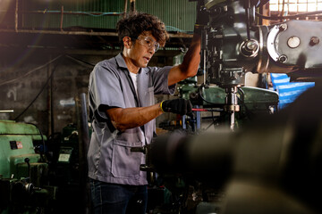 Engineer worker in production plant drilling at machine. Professional worker near drilling machine on factory. man inspecting and repairing machine for operation in workshop.