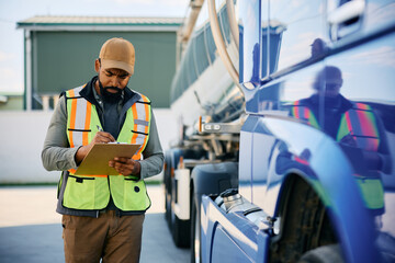 Black truck dispatcher checking shipment list on parking lot. - obrazy, fototapety, plakaty