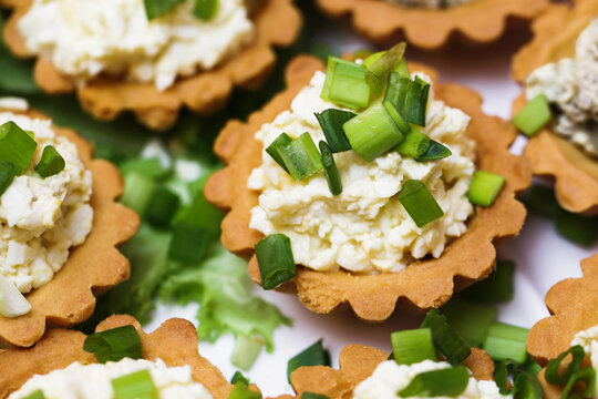 Egg paste cupcake. Egg spread tartlets. Boiles eggs with mayo on baked tarta cake sprinkled with chives onion spring. Salty party snack. Eggs salad on tartlet.