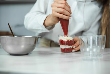 Process of creating red velvet trifle. Confectioner at work