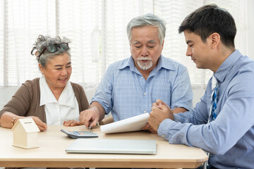 Asian retired senior couple reading property sign contract agreement before purchasing asset or...