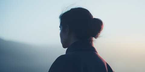 Serene silhouette of a young woman in early morning haze