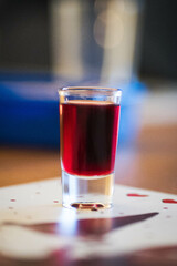 small glass with red alcohol celebrating  