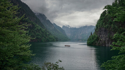 View to lake Königssee from viewpoint Malerwinkel during moody weather, tourist boats on the...