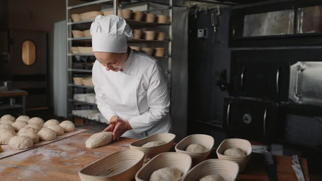 Baker preparing formed bread dough for proofing
