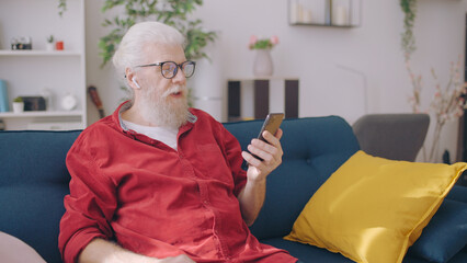 Senior man conversing with coworkers, addressing business matters remotely as a freelancer