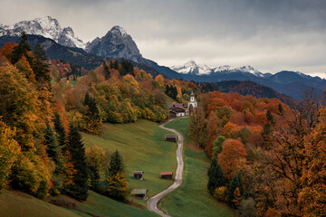 Bavarian Alps with church of Wamberg in Garmisch-Partenkirchen during autumn, snow-covered...
