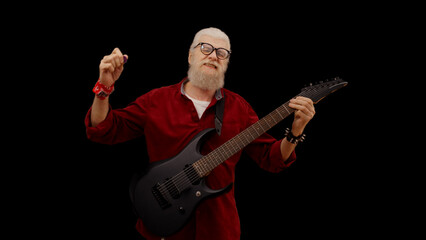 Modern mature man enjoys playing the electric guitar against a black background, living his rockstar dream