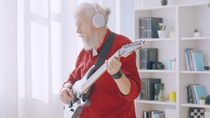 A contemporary senior man plays the electric guitar, embodying the spirit of forever young and rock and roll