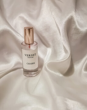 Verset parfums Charm women fragrance bottle on a light white shiny soft silk satin background