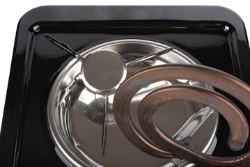 Close-up of the heating element of a tabletop electric stove raised for cleaning.