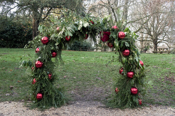 archway decorated with fir laurel and bright red baubles