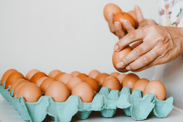 Close up of a woman holding a tray of free-range red eggs. The egg has nutrients with antioxidant...