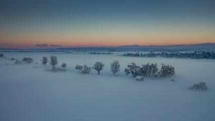 Bavarian winter landscape with snow during winter and sunset from above, snow field and trees, Bavaria Germany. - 702369926