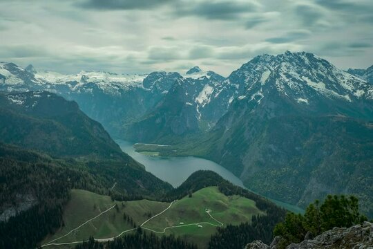 Timlapse of moving clouds above lake K&ouml;nigssee at Berchtesgaden Bavaria, mountain scenery in the background with snow-capped mountains.