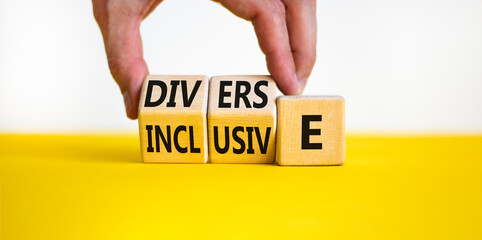 Diverse and inclusive symbol. Concept word Diverse and Inclusive on wooden cubes. Beautiful yellow table white background. Businessman hand. Business diverse and inclusive concept. Copy space.