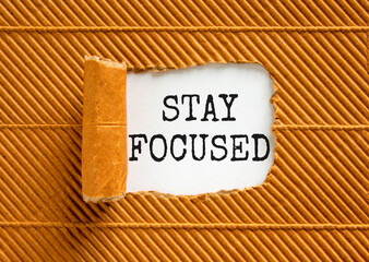 Stay focused symbol. Concept words Stay focused on beautiful white paper on a beautiful brown paper...