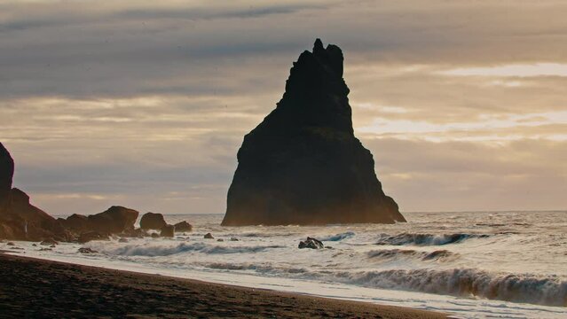 Pointy rocks sticking out of the ocean at Reynisfjara, Black sand Beach near Vik in Iceland