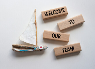 Welcome to our team symbol. Concept words Welcome to our team on wooden blocks. Beautiful white...