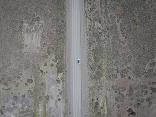 aerial view of a car on the road in the pampas to the end of the world