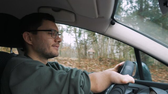 A disabled person drives a car. He smiles and relaxes. Traveling by car.
