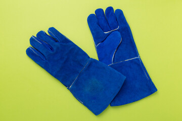Blue construction gloves on color background, top view