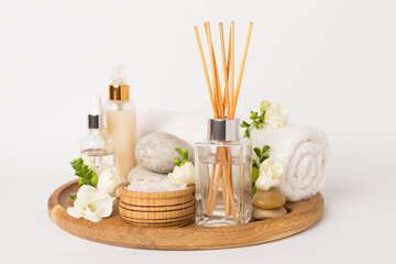 Spa composition with freesia flower and aroma diffuser on white background